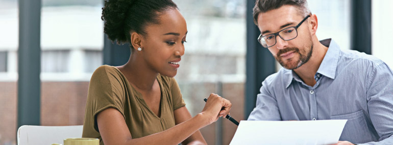 Man and woman reviewing documents at the table.