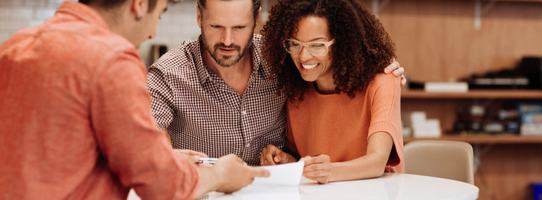 A couple having a discussion with another individual at the table.