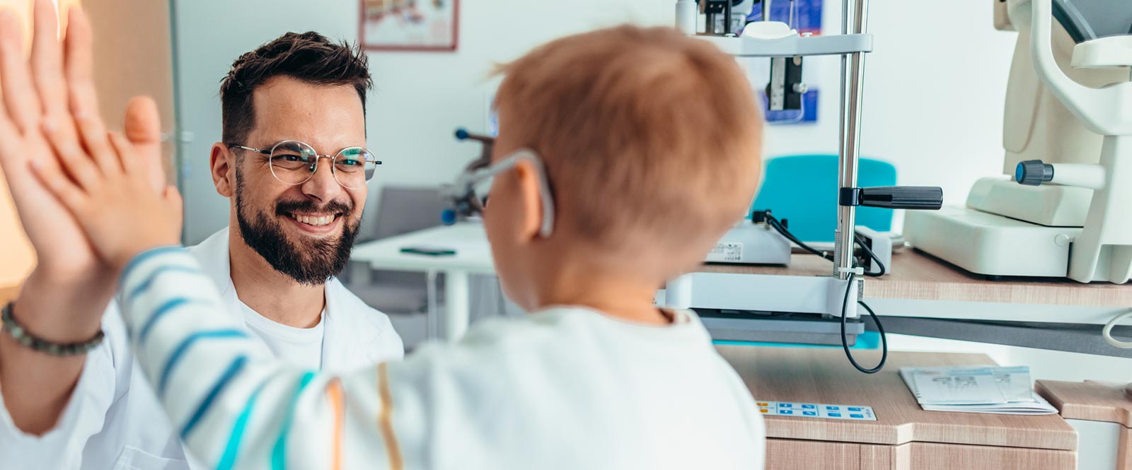 Doctor high fiving young patient.