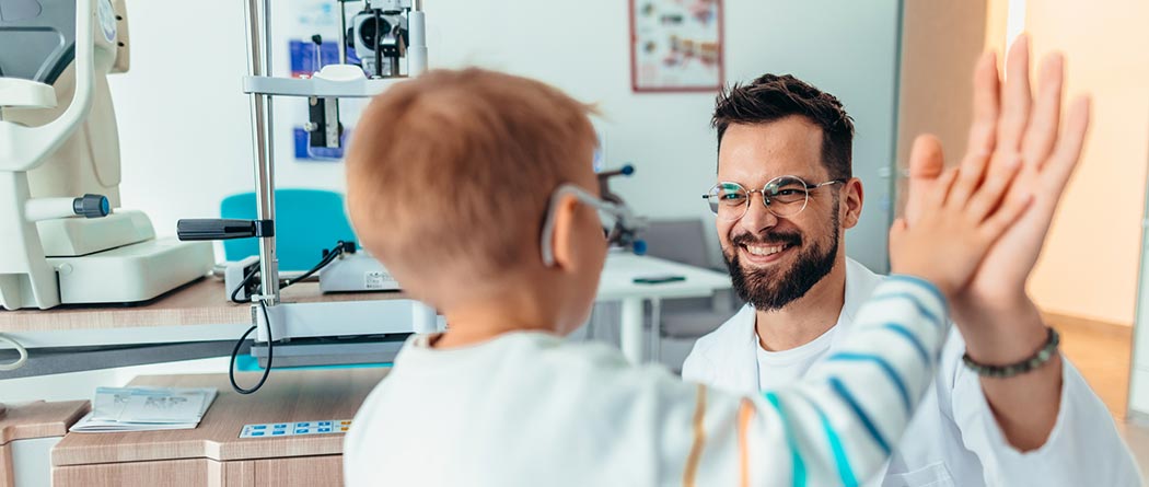 Doctor high fiving young child.